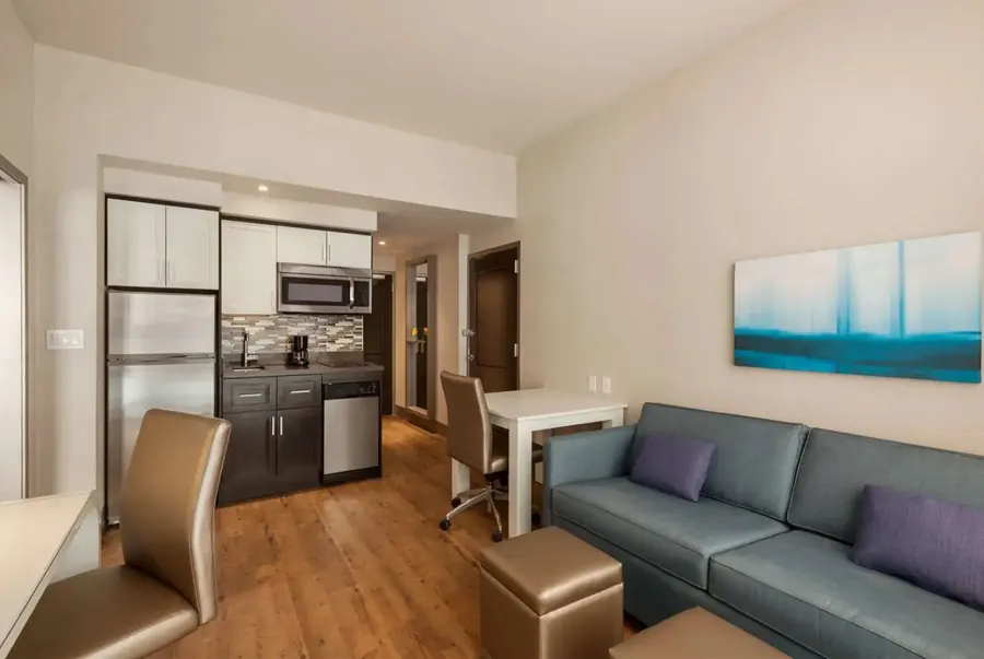 Extended stay hotel suite showing modern kitchenette and open-plan living room