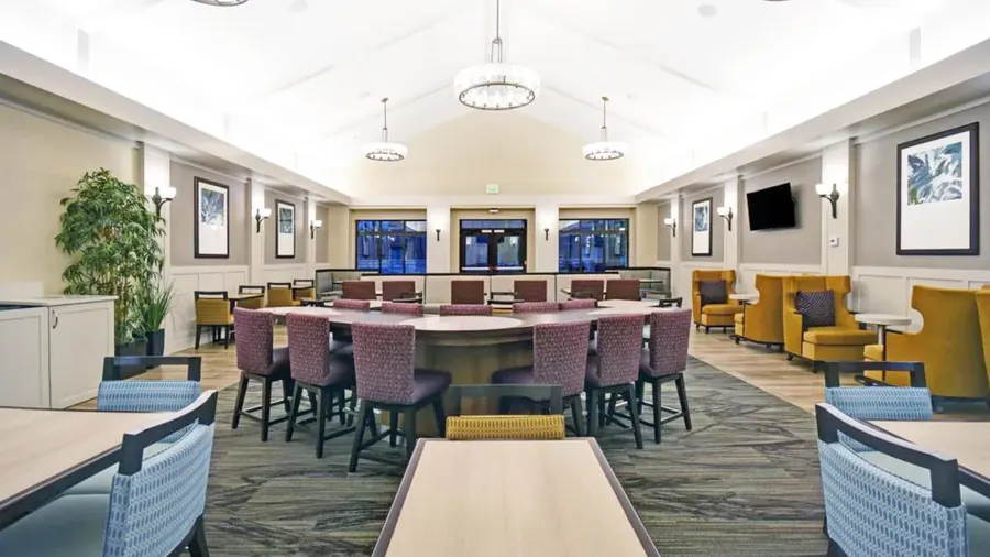 Formal dining and banquet room with elegant chandeliers and upholstered dining armchairs